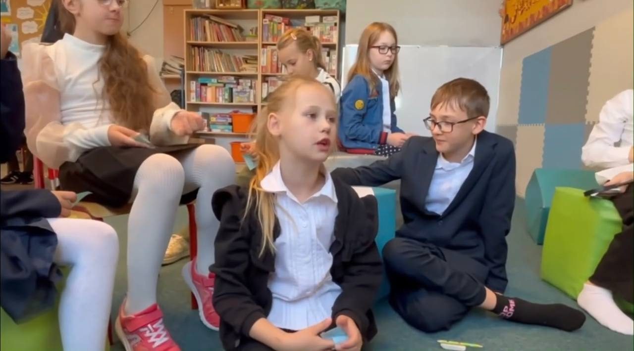 Dzieci rozmawiają, siedząc w kręgu